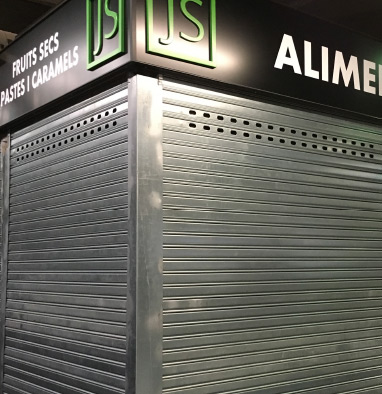 Persiana metálica comercial enrollable instalada en tienda